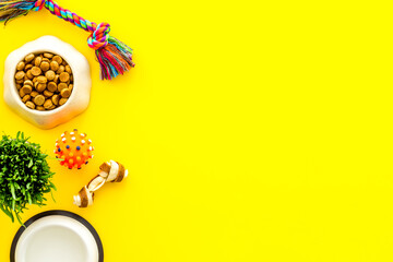 Dry dog food in bowl with toys and treats, top view