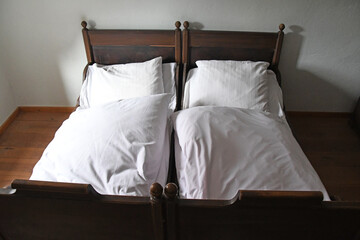 altes Doppelbett mit weißer Bettwäsche - obrazy, fototapety, plakaty