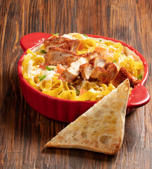 Pasta con pollo sobe fondo donde madera, comida italiana. Pasta with chicken on the bottom where wood, Italian food.