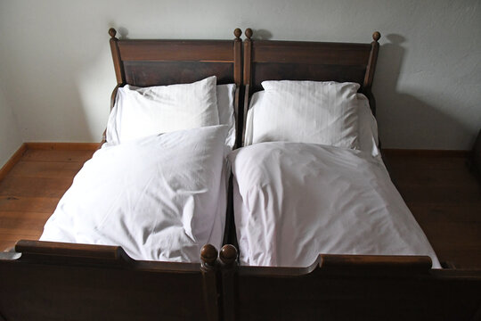 altes Doppelbett mit wei&szlig;er Bettw&auml;sche