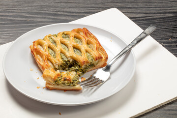 Empanada de verduras sobre plato de porcelana blanca