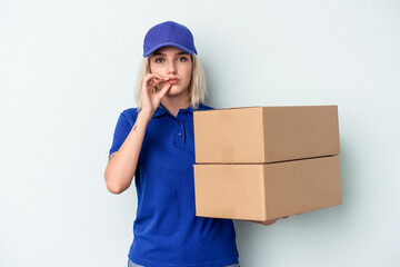 Young delivery caucasian woman isolated on blue background with fingers on lips keeping a secret.