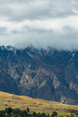 Fototapeta premium ニュージーランド クイーンズタウンのワカティプ湖の湖畔から見える雲のかかったリマーカブルズ山脈