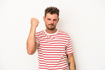 Young caucasian man isolated on white background showing fist to camera, aggressive facial expression.