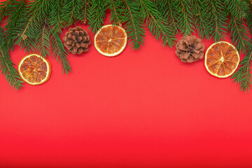 Cones and slices of dried orange on spruce branches