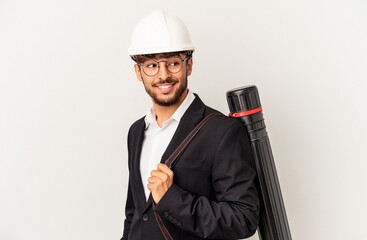 Young mixed race architect man wearing a helmet isolated on grey background looks aside smiling, cheerful and pleasant.