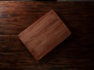 Tabla de madera rectangular vacía sobre mesa de madera. Empty rectangular wooden board on wooden table.