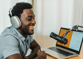Positive black man talking in mic and recording podcast