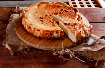 Tarta de queso sobre tabla de madera. Cheesecake on wooden board.
