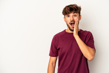 Young mixed race man isolated on grey background shouts loud, keeps eyes opened and hands tense.