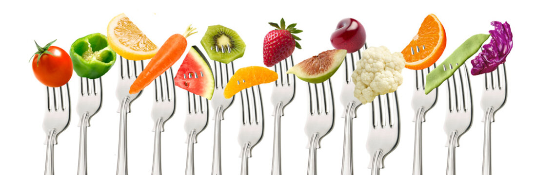 Fruta  y verduras  en tenedor  sobre fondo blanco. Fruit and vegetables on fork on white background.