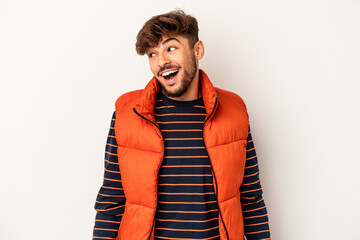 Young mixed race man isolated on grey background laughs and closes eyes, feels relaxed and happy.