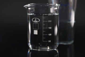 Closeup of chemical beaker with water on black background