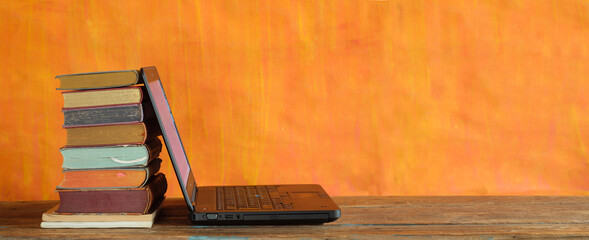 Stack of books and laptop computer ,home office, homeschooling,reading,education, business concept. Free copy space, panoramic
