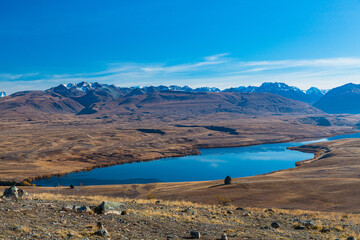 ニュージーランド　カンタベリー地方のテカポにあるマウントジョンの山頂から望むアレクサンドリーナ湖とマッケンジー盆地と南アルプス山脈