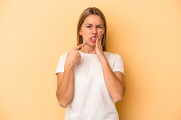 Young caucasian woman isolated on yellow background having a strong teeth pain, molar ache.