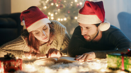 Coppia di ragazzo e ragazza leggono libro a Natale
