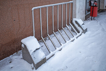 Snow-covered bicycle parking near the entrance to the building