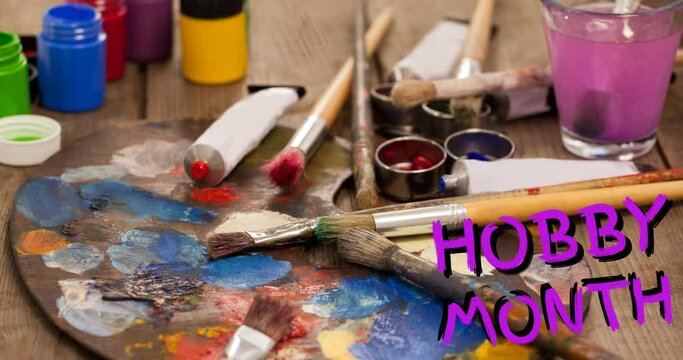 Animation of hobby month text in pink, over oil paints, paintbrushes and palette on table