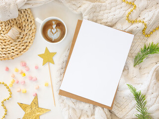 Paper sheet xmas card mockup with holiday decorations in green and golden colors on white background. Top view Christmas and New Year planning flatlay concept.