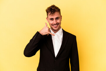 Young caucasian business man isolated on yellow background showing a mobile phone call gesture with fingers.