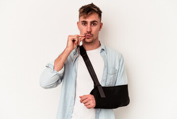 Young caucasian man with broken hand isolated on white background with fingers on lips keeping a secret.