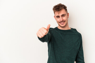 Young caucasian man isolated on white background smiling and raising thumb up