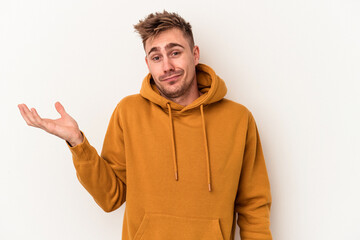 Young caucasian man isolated on white background doubting and shrugging shoulders in questioning...