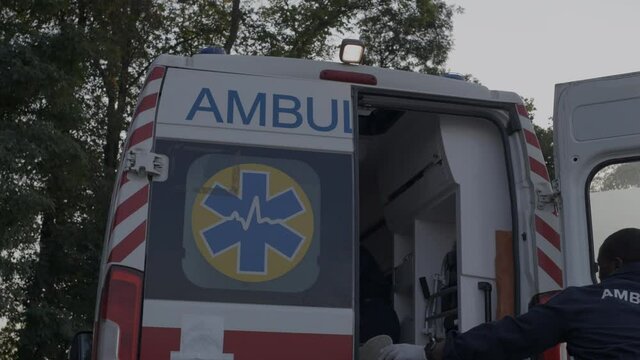 African american paramedic in hurry closing door of ambulance car