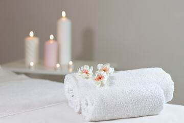 Fototapeta na wymiar Warm herbal massage table with towels and candles