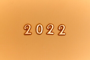 Holiday background  Numbers of year 2022 made by gold candles on bokeh festive sparkling background. celebrating New Year holiday, close-up. Space for text
