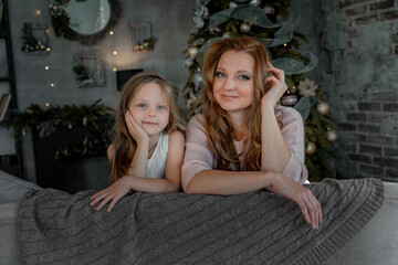 Head shot portrait beautiful young mother embrace little daughter supporting and caring sitting in living room at home spend time together.