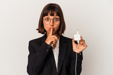 Young mixed race business woman holding a phone charger isolated on white background showing a disappointment gesture with forefinger.