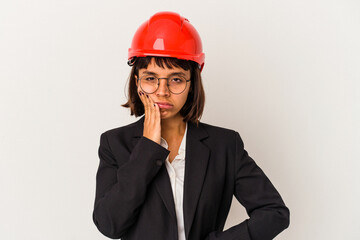 Young architect woman with red helmet isolated on white background who is bored, fatigued and need a relax day.