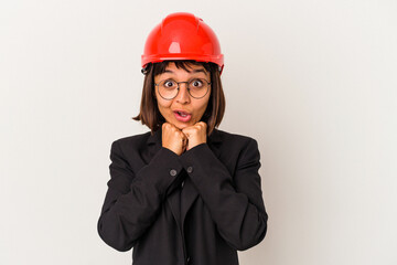 Young architect woman with red helmet isolated on white background praying for luck, amazed and opening mouth looking to front.