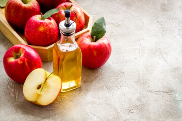 Homemade apple cider vinegar in glass bottle with red apples