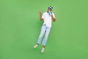 Full size photo of cool millennial brunet guy drink beverage jump wear white t-shirt jeans shoes...