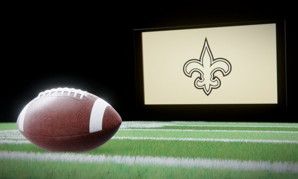American football in foreground with logo of NFL team New Orleans Saints projected on screen in background. Editorial 3D illustration