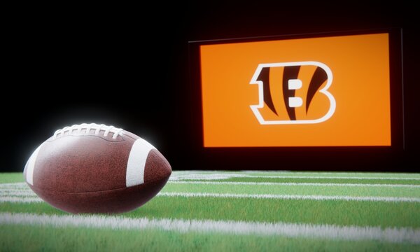 American football in foreground with logo of NFL team Cincinnati Bengals projected on screen in background. Editorial 3D illustration