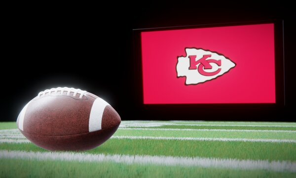 American football in foreground with logo of NFL team Kansas City Chiefs projected on screen in background. Editorial 3D illustration