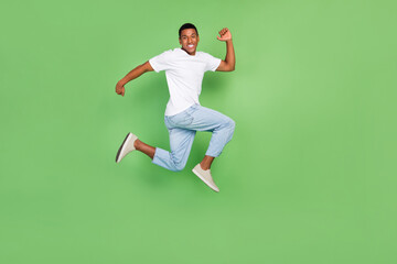 Fototapeta na wymiar Full body profile side photo of young afro man good mood run walk jump discount isolated over green color background
