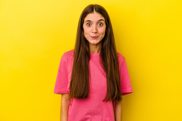 Young caucasian woman isolated on yellow background sad, serious face, feeling miserable and displeased.