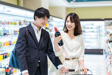 お店でワインを購入する若い夫婦