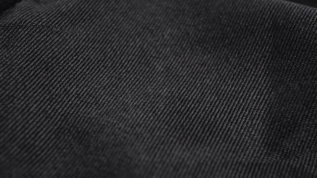 Textured black grunge textile material. Macro. Slow rotation. Abstract texture