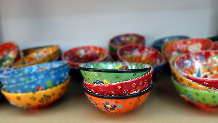 Fototapeta na wymiar Traditional bulgarian products for sale. Hand made bowls in different colours. Selective focus, panoramic view