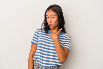 Young latin woman isolated on white background  surprised pointing with finger, smiling broadly.
