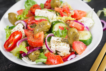 Greek salad of fresh  tomato, sweet pepper, cucumber, red onion, feta cheese and green olives. Healthy vegetarian food.