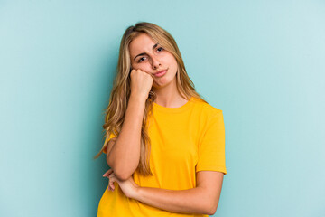 Young caucasian blonde woman isolated on blue background  who feels sad and pensive, looking at copy space.