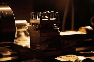 Close up of industrial machines indoors in metal workshop at night.