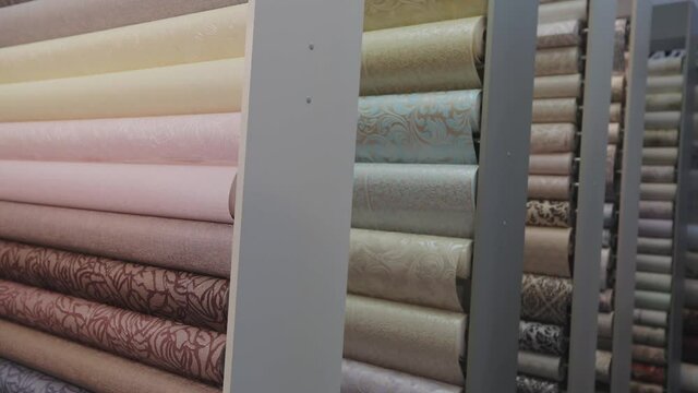 Stands with new samples. Rolls with wallpaper. Stands with rolls of wallpaper samples in the store. Wallpaper with patterns